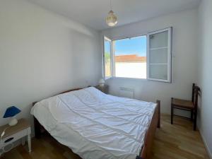 1 dormitorio con cama y ventana en Maison Bretignolles-sur-Mer, 3 pièces, 5 personnes - FR-1-231-299, en Bretignolles-sur-Mer