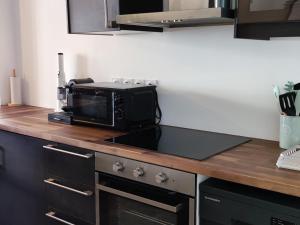 - un four micro-ondes installé au-dessus d'un comptoir dans la cuisine dans l'établissement Appartement Le Lavandou, 2 pièces, 4 personnes - FR-1-677-33, au Lavandou