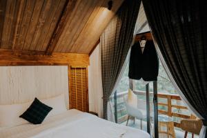 a bedroom with a bed and a balcony at Amaya Retreat in Sóc Sơn