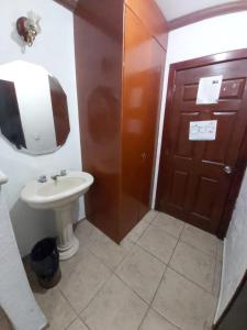 a bathroom with a sink and a brown door at Hotel Estación Guadalajara in Guadalajara