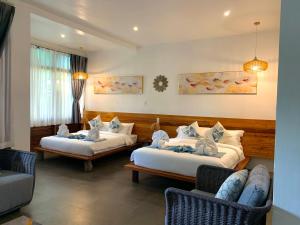 Habitación de hotel con 2 camas y 2 sillas en Infinity Diving Resort and Residences, en Dauin