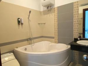 ein Badezimmer mit einer Badewanne, einem WC und einem Waschbecken in der Unterkunft THIÊN SANG HOTEL in Xuan An