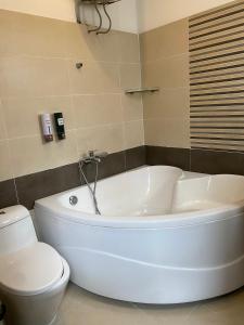 ein Badezimmer mit einer weißen Badewanne und einem WC in der Unterkunft THIÊN SANG HOTEL in Xuan An