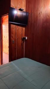 1 dormitorio con 1 cama y pared de madera en HOSTAL DELIA PUCON, en Pucón
