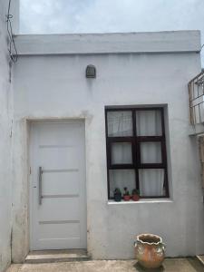 um edifício branco com uma porta e uma janela em Monoambiente em Corrientes