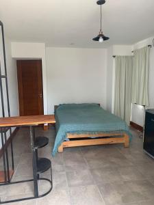 um quarto com uma cama e uma mesa de madeira em Monoambiente em Corrientes