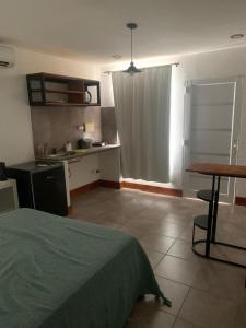 um quarto com uma cama, uma mesa e uma cozinha em Monoambiente em Corrientes