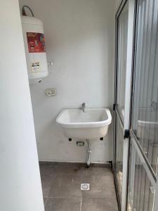 um lavatório branco numa casa de banho com uma janela em Monoambiente em Corrientes