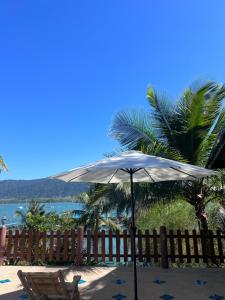 a white umbrella and a chair next to a fence at Island View Resort Koh Chang in Ko Chang