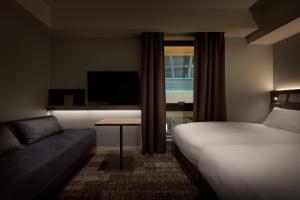 大阪市にあるネストホテル大阪梅田のベッドとソファ付きのホテルルーム
