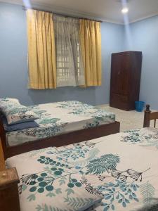 - une chambre avec 2 lits jumeaux et une fenêtre dans l'établissement BUTIK VILLA, à Port Dickson