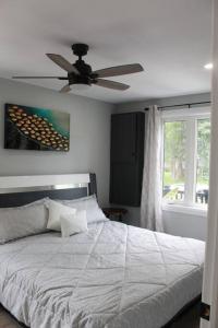 um quarto com uma cama e uma ventoinha de tecto em Smitty's Lake House Retreat 