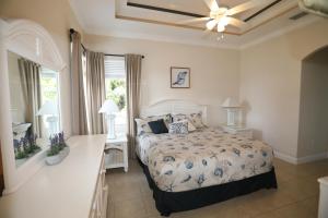 una camera da letto con un letto e un ventilatore a soffitto di Heated Pool house a Rotunda-West Altre 24 foto