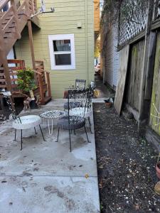 un grupo de sillas y una mesa frente a una casa en Bumblebee House en Oakland