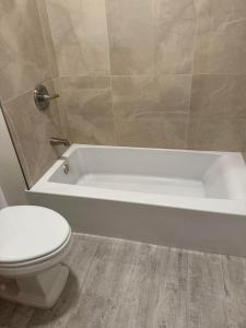 a bathroom with a toilet and a bath tub at Bumblebee House in Oakland