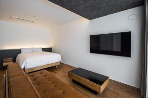 a bedroom with a bed and a flat screen tv at Hotel Dios - Vacation STAY 31424v in Awaji