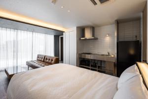 a bedroom with a large white bed and a kitchen at Hotel Dios - Vacation STAY 31424v in Awaji