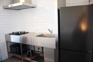 eine Küche mit einer Spüle und einem schwarzen Kühlschrank in der Unterkunft Hotel Dios - Vacation STAY 40406v in Awaji