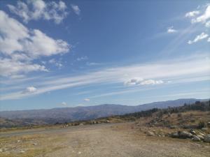 an empty road in the mountains under a blue sky at Pitec Hostel Lodge in Huaraz