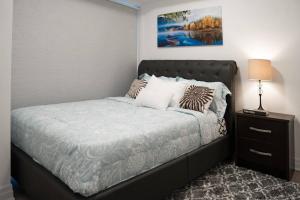 a bedroom with a bed and a night stand with a lamp at Cozy 1.5 Bedroom near Square One in Mississauga