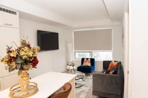 a living room with a table with a vase of flowers at Cozy 1.5 Bedroom near Square One in Mississauga
