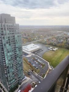 an aerial view of a tall building with a parking lot at Cozy 1.5 Bedroom near Square One in Mississauga