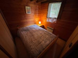 a bedroom with a bed in a wooden cabin at Charmant chalet semi-mitoyen avec 3 chambres, jardin et balcon près de la nature - FR-1-593-107 in Les Angles +2 photos