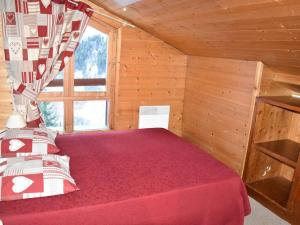 a bedroom with a red bed in a wooden cabin at Appartement Pralognan-la-Vanoise, 4 pièces, 8 personnes - FR-1-464-224 in Pralognan-la-Vanoise