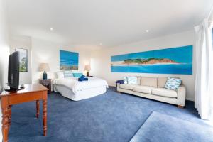 - une chambre avec un lit, un canapé et une télévision dans l'établissement Stoneferry- A Beachfront Beauty - Free Wifi, à Port Elliot