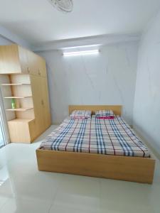 a bedroom with a bed in a white room at NATURAL HOUSE hostel in Ho Chi Minh City