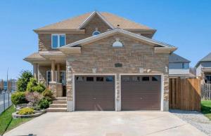 a house with a brown garage door at Cozy Homestay Waterloo Airport II in Kitchener