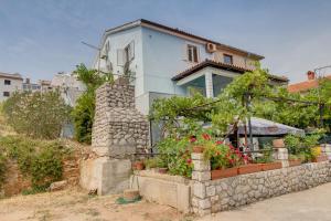 a house with flowers and plants in front of it at Apartment Mario in Mali Lošinj