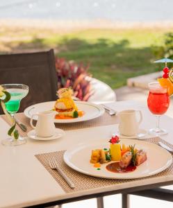 uma mesa com dois pratos de comida e bebidas em The Shells Resort & Spa Phu Quoc em Phu Quoc