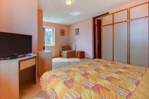 a bedroom with a bed and a flat screen tv at Apartment Mario in Mali Lošinj
