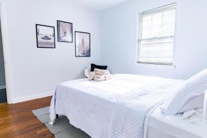 ein weißes Schlafzimmer mit einem Bett und einem Fenster in der Unterkunft Luxury home 5 mins to Mercedes-Benz Stadium in Atlanta