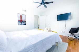 ein weißes Schlafzimmer mit einem Bett und einem Deckenventilator in der Unterkunft Luxury home 5 mins to Mercedes-Benz Stadium in Atlanta