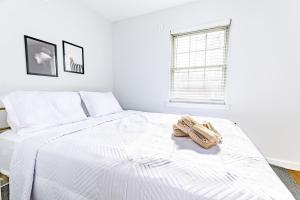 ein weißes Schlafzimmer mit einem Bett und einem Handtuch darauf in der Unterkunft Luxury home 5 mins to Mercedes-Benz Stadium in Atlanta