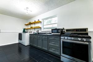 eine Küche mit schwarzen und weißen Geräten und einem Fenster in der Unterkunft Luxury home 5 mins to Mercedes-Benz Stadium in Atlanta