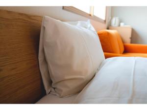 białą poduszkę siedzącą na łóżku w obiekcie ＳＯ Ｋｙｏｔｏ Ｆｕｓｈｉｍｉ Ｉｎａｒｉ - Vacation STAY 76154v w mieście Kioto