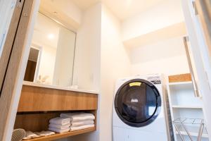 a washing machine in a bathroom with a mirror at ＳＯ Ｋｙｏｔｏ Ｆｕｓｈｉｍｉ Ｉｎａｒｉ - Vacation STAY 76154v in Kyoto