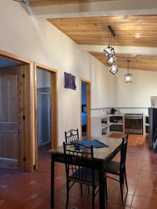a dining room with a table and chairs and a kitchen at Casa Atitlan I in San Juan La Laguna