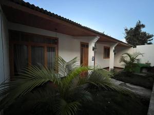 una casa blanca con palmeras delante en Casa Atitlan I, en San Juan La Laguna