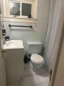 a white bathroom with a toilet and a sink at Roomy Oasis DC area pet friendly in Takoma Park