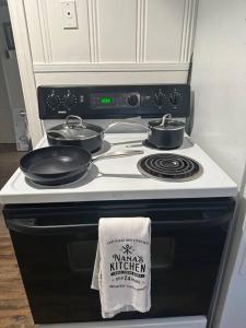 a stove with three pots and pans on top of it at Roomy Oasis DC area pet friendly in Takoma Park