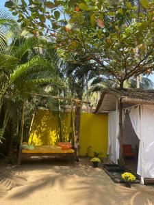 eine Schaukel im Sand unter einem Baum in der Unterkunft Art Resort Goa in Palolem