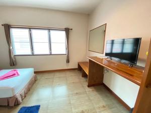 Schlafzimmer mit einem Bett und einem Flachbild-TV in der Unterkunft Lotus Hostel Beach Koh Tao in Ko Tao