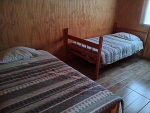 1 dormitorio con 2 camas y ventana en CABAÑAS BRISAS VOLCANICAS, en Cunco