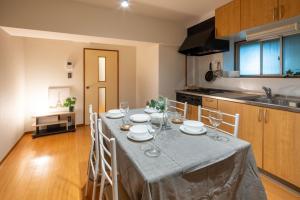 a kitchen with a table with plates and wine glasses at Sunny Heights Osaki - Vacation STAY 14998 in Tokyo