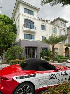 a red and white car parked in front of a house at QUEEN VILLA in Ha Long