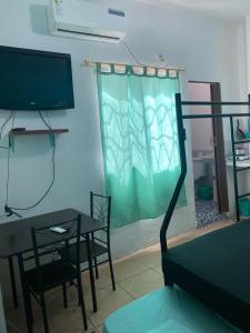 Playa Malecón, suites y Apart’s في مانتا: غرفة معيشة مع طاولة وتلفزيون
